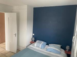 a bedroom with a blue wall and a bed with pillows at Apartment with mountain view in Espelette