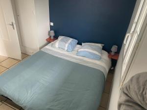 a bed in a room with a blue wall at Apartment with mountain view in Espelette