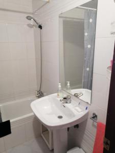 ein Badezimmer mit Waschbecken, Spiegel und Badewanne in der Unterkunft Bonita piscina y playa de gandia in Puerto de Gandía