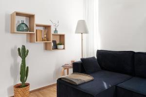 a living room with a blue couch and a cactus at La Maison Blue, between Portello-Fiera-MiCo-CityLife in Milan