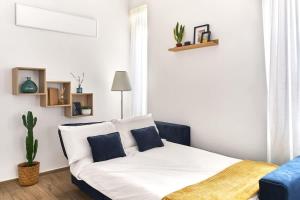 a white bed with blue pillows in a room at La Maison Blue, between Portello-Fiera-MiCo-CityLife in Milan