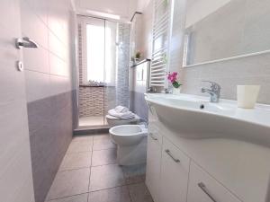 Un baño blanco con lavabo e inodoro. en Utri House by Holiday World, en Génova 15 fotos más