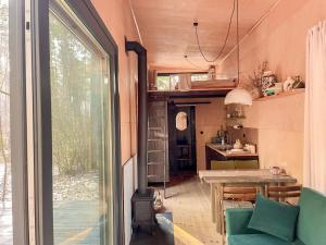 Habitación con mesa y cocina con ventana en Carthome - wyjątkowe miejsce leśnego wypoczynku, en Zynie