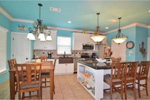 a kitchen with blue walls and a table and chairs at Sum Beach in Crystal Beach