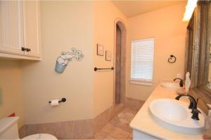 a bathroom with a sink and a toilet and a shower at Sum Beach in Crystal Beach