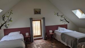 sypialnia z 2 łóżkami i oknem w obiekcie La Maison d'à Côté w mieście Saint-Amand-en-Puisaye
