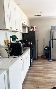 a kitchen with white cabinets and a refrigerator at Orange County Homes in Santa Ana