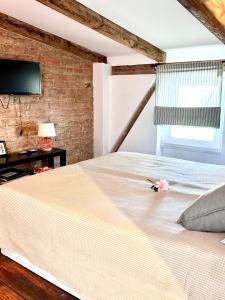een slaapkamer met een bed en een bakstenen muur bij Pocztówka Spod Dachu in Sopot