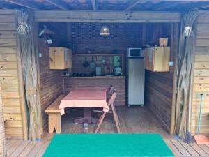 a small kitchen with a table and a refrigerator at Bangalô in Ilha de Boipeba