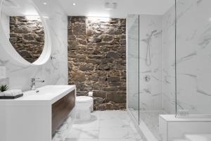 a white bathroom with a stone wall at The SFX Old Port in Montreal