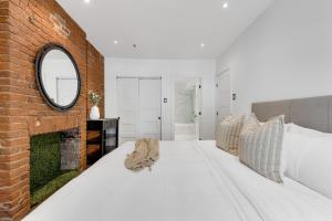 a bedroom with a large white bed and a brick wall at The SFX Old Port in Montreal