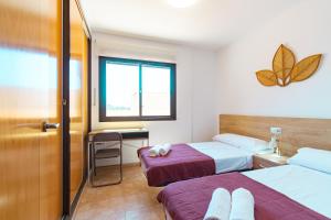 a bedroom with two beds and a desk and a window at Apartamento con terraza y piscina en Los Collados - By Aloha Palma in Águilas +57 photos