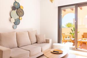 a living room with a white couch and a table at Apartamento con terraza y piscina en Los Collados - By Aloha Palma in Águilas