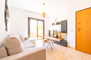 a living room with a white couch and a table at Apartamento con terraza y piscina en Los Collados - By Aloha Palma in Águilas