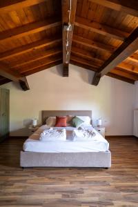 a bedroom with a large bed with wooden ceilings at Borgo Segreto del Garda in Monzambano +140 photos