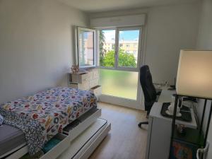 a bedroom with a bed and a desk and a window at Chambres près des 24H avec 1 lit et 1 lit d'appoint -60kg in Le Mans