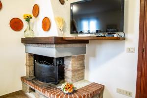 a fireplace with a television on top of it at Agriturismo Le Chiocciolaie - Appartamento 2 in Podere Cernaia