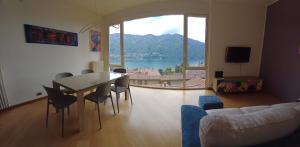 a living room with a table and chairs and a large window at Casa Bice Cernobbio in Cernobbio