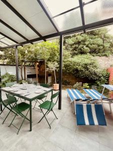 a patio with a table and chairs under a pergola at "Maison Bleue" Quartier Haut,Clim,Parking,Jardin in Sète