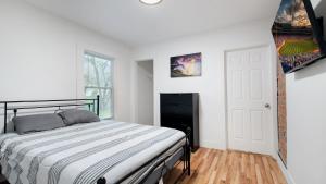 a white bedroom with a bed and a fireplace at 6 bedroom House Short Walk to Niagara Falls in Niagara Falls