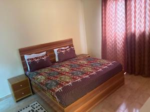a bedroom with a bed and a window with curtains at Ouest foire in Dakan