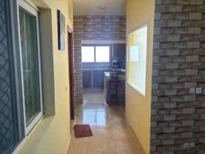 a hallway leading to a kitchen with a brick wall at Ouest foire in Dakan