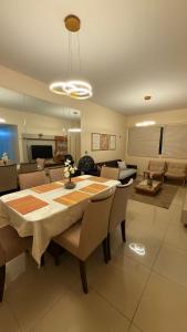 a dining room table with chairs and a living room at Lindo apartamento 50 metros da praia in Cabedelo