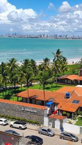 a view of the beach and the ocean with palm trees at Lindo apartamento 50 metros da praia in Cabedelo +23 photos