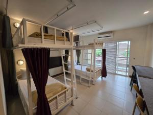 a bedroom with two bunk beds in a room at JB Mansion Hotel in Chiang Rai