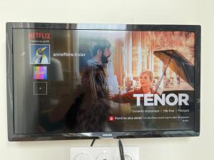 a television screen with a picture of a man at Chambre dans ancienne ecole in Cazères-sur-lʼAdour