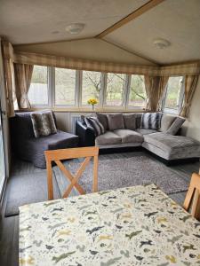 a living room with a couch and a table at Silver Birch Nabb Lane Hot tub near Alton Towers in Combridge +24 photos