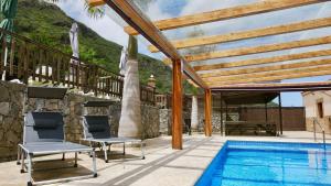 un patio con 2 sillas junto a una piscina en Villa El Guanche, en Gáldar