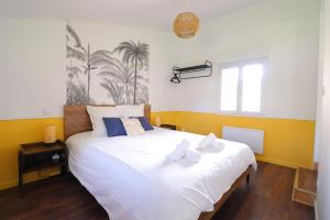 ein Schlafzimmer mit einem großen weißen Bett mit Handtüchern darauf in der Unterkunft L'Amazone - T2 Cosy et Lumineux in La Force