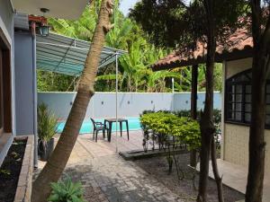 a patio with a table and chairs next to a pool at Rede Elevare Ilha do Sol in Florianópolis