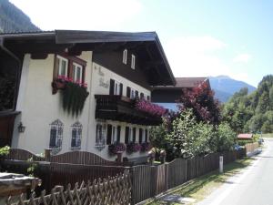 a house with flowers on the windows and a fence at Appartements Haus Schmalzl in Viehhofen +10 photos