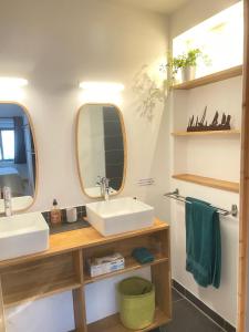 a bathroom with two sinks and a mirror at Entre terre et mer in Montfarville