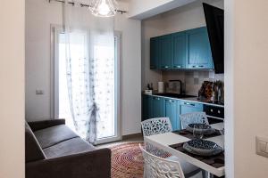 a kitchen with blue cabinets and a table and chairs at Casa vacanza Paradiso sul mare a Brolo in Brolo