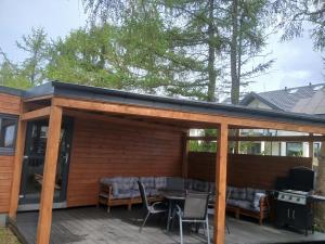 a pavilion with a table and chairs on a deck at Wakacyjny dom in Karwia