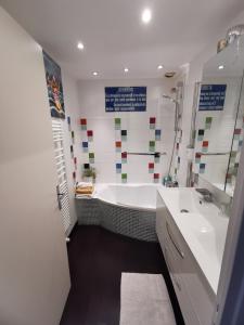 ein Badezimmer mit großer Badewanne und Waschbecken in der Unterkunft espace privé, balcon vue montagnes pour 1 à 4 personnes in Grenoble + 9 Fotos