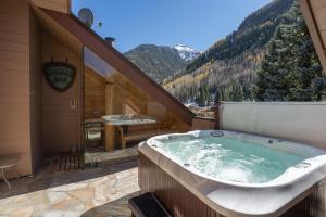 a jacuzzi tub on a balcony with a mountain at Rivercrown 7 by Exceptional Stays in Telluride