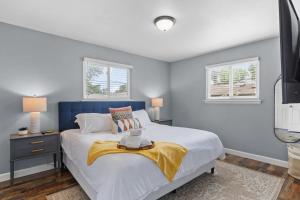 a bedroom with a large bed and two windows at 3 Bedroom House with Firepit St. Peters, MO in Saint Peters