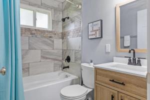 a bathroom with a toilet and a sink and a bath tub at 3 Bedroom House with Firepit St. Peters, MO in Saint Peters +16 photos