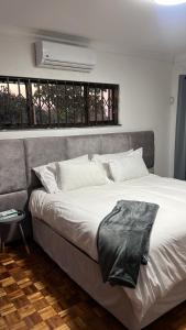 a bedroom with a large white bed and a window at 8 on Lorenzo in Amanzimtoti