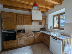 a kitchen with wooden cabinets and a white stove top oven at Le gîte de Saury in Lathuile