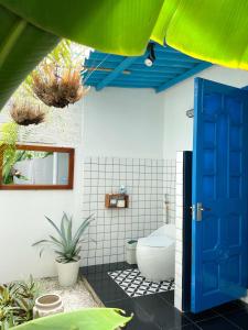 a bathroom with a toilet and a blue door at QiHome Phú Quý in Cu Lao Thu