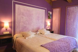 een slaapkamer met paarse muren en een bed met 2 lampen bij Via Stellae in Tamallancos +77 foto's
