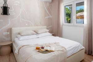 una camera da letto con un letto bianco con scarpe e libri di VILLA TUGARKA private pool, fitness, play-house, great for families, max 6 per. a Tugare Altre 40 foto