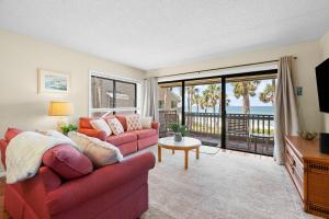 un soggiorno con un divano rosso e vista sull'oceano di Beachfront Aldea 6 a Clearwater Beach