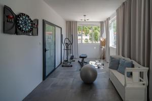 un soggiorno con un divano e un bersaglio per le freccette di VILLA TUGARKA private pool, fitness, play-house, great for families, max 6 per. a Tugare
