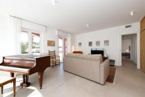 a living room with a piano and a couch at MGH - Malcesine Supreme Stay in Malcesine